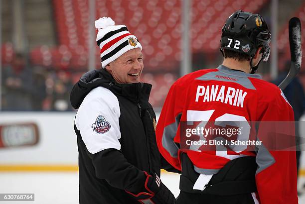 Assistant coach Mike Kitchen of the Chicago Blackhawks talks with Artemi Panarin during practice for the 2017 Bridgestone NHL Winter Classic at Busch...