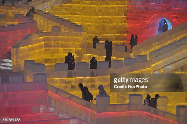 People visit the ice sculptures illuminated by coloured lights at Harbin ice and snow world to celebrate the new year in Harbin city of China on...