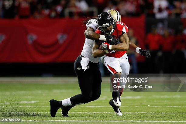 Devonta Freeman of the Atlanta Falcons is tackled by Dannell Ellerbe of the New Orleans Saints on a run during the first half at the Georgia Dome on...