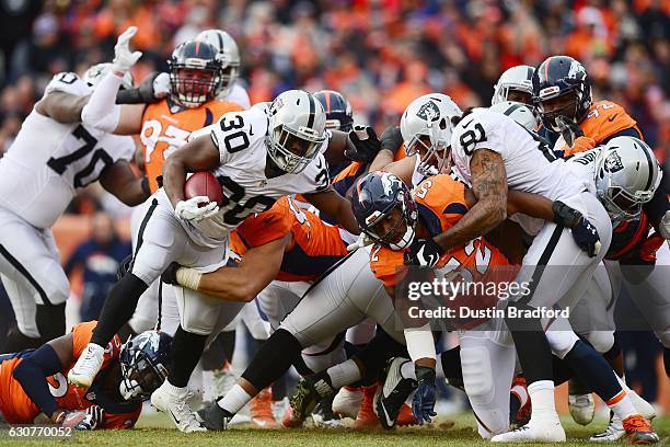 Running back Jalen Richard of the Oakland Raiders is tackled by defensive tackle Adam Gotsis of the Denver Broncos in the first quarter at Sports...