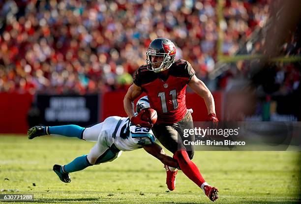 Wide receiver Adam Humphries of the Tampa Bay Buccaneers runs for a gain of 17 yards to bring up first and goal while getting pressure from defensive...