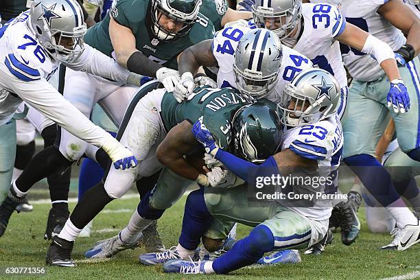 Terrell Watson of the Philadelphia Eagles is tackled by Leon McFadden and Randy Gregory, both of the Dallas Cowboys, during the fourth quarter at...