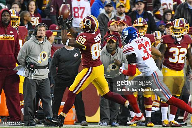 Washington Redskins wide receiver Pierre Garcon pulls in a pass against the first quarter defense of New York Giants free safety Andrew Adams on...