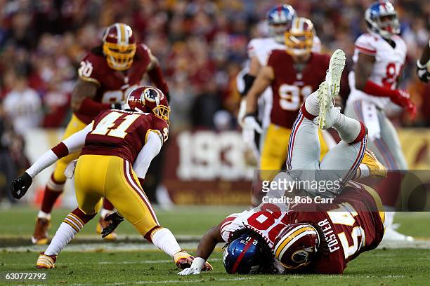 Running back Paul Perkins of the New York Giants is tackled by inside linebacker Mason Foster of the Washington Redskins in the first quarter at...