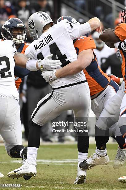 Jared Crick of the Denver Broncos hits Matt McGloin of the Oakland Raiders during the second quarter on Sunday, January 1, 2017. The Denver Broncos...