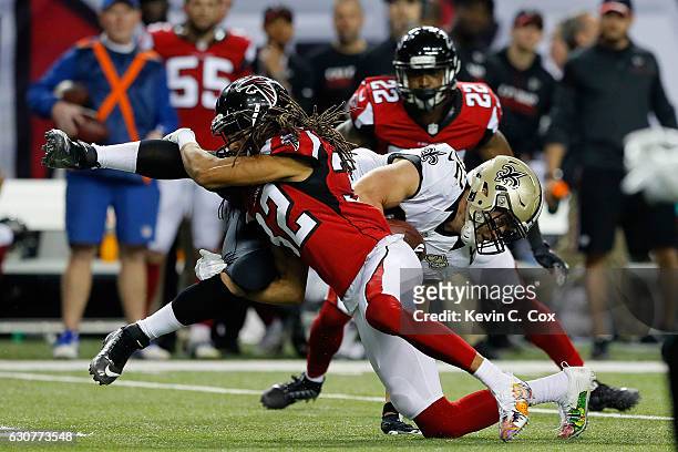 Patrick DiMarco of the Atlanta Falcons tackles Coby Fleener of the New Orleans Saints during the first half at the Georgia Dome on January 1, 2017 in...
