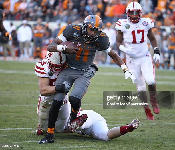 Joshua Dobbs Tennessee Volunteers quarterback breaks free from Josh Banderas Nebraska Cornhuskers linebacker to score during the Franklin American...