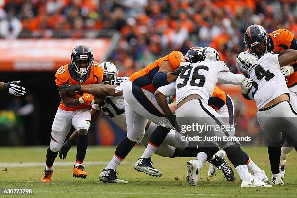 Running back Justin Forsett of the Denver Broncos rushes and is tackled by outside linebacker Bruce Irvin of the Oakland Raiders in the second...