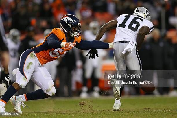 Wide receiver Johnny Holton of the Oakland Raiders fumbles the ball in the fourth quarter of the game against the Denver Broncos at Sports Authority...