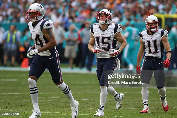 Michael Floyd, Chris Hogan and Julian Edelman of the New England Patriots play against the Miami Dolphins at Hard Rock Stadium on January 1, 2017 in...
