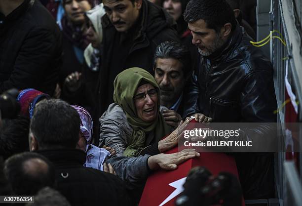 Relatives of security member Fatih Cakmak who died in the Reina night club attack, mourn during the funeral ceremony on January 2, 2017 in Istanbul....