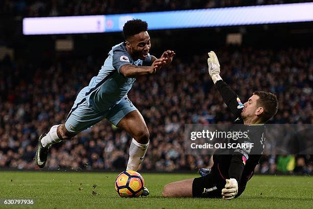 Burnley's English goalkeeper Tom Heaton dives to save a shot from Manchester City's English midfielder Raheem Sterling during the English Premier...