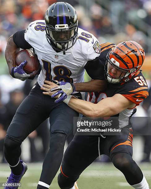 Breshad Perriman of the Baltimore Ravens runs the ball as Nick Vigil of the Cincinnati Bengals attempts the tackle at Paul Brown Stadium on January...