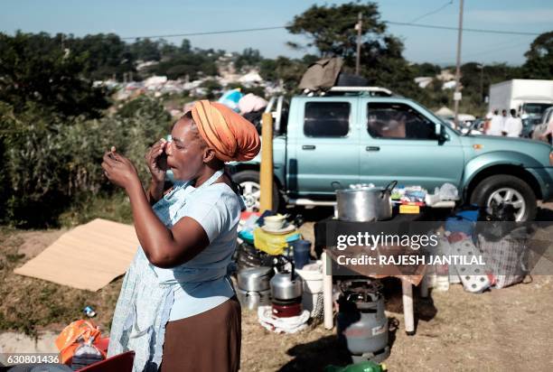 Follower of the Nazareth Baptist Church, also known as the Shembe Church, places a lotion to protect her face against the heat of the sun as she...