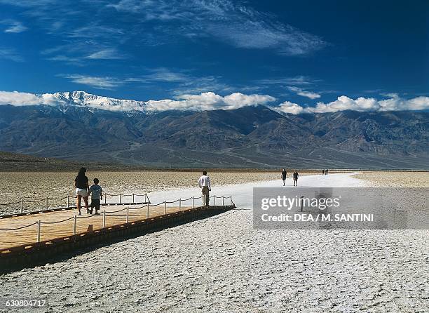 Tourists walking on a salt path, Badwater basin , Death Valley national park, United States of America.