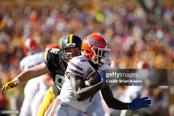 Wide receiver Antonio Callaway of the Florida Gators evades defensive end Matt Nelson of the Iowa Hawkeyes during a carry in the first quarter of the...