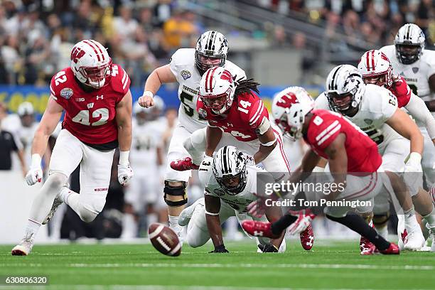 Natrell Jamerson, Leo Musso, Sojourn Shelton, D'Cota Dixon, and Derrick Tindal of the Wisconsin Badgers dive after a fumble in the second quarter...