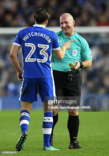 Referee Simon Hooper speaks with Sam Hutchinson of Sheffield Wednesday before showing him a yellow card for a tackle on Connor Ronan of Wolverhampton...