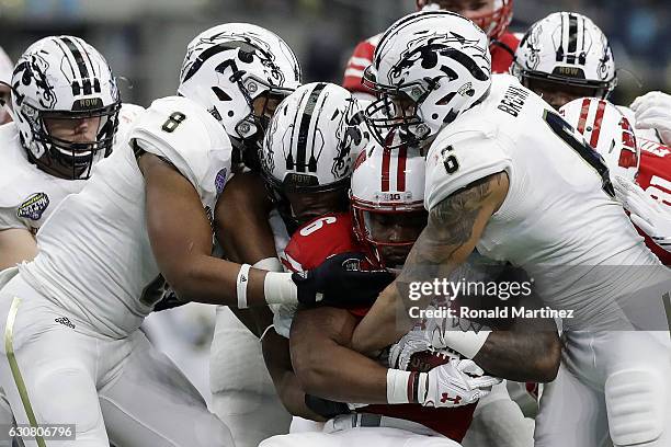Asantay Brown and Caleb Bailey of the Western Michigan Broncos tackle Sojourn Shelton of the Wisconsin Badgers inthe third quarter during the 81st...