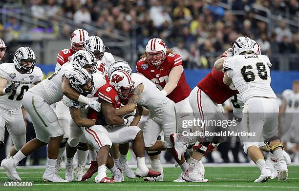 Asantay Brown and Caleb Bailey of the Western Michigan Broncos tackle Sojourn Shelton of the Wisconsin Badgers inthe third quarter during the 81st...