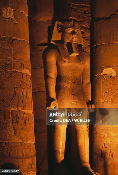 View of a colossal statue of the Temple of Amun at night, Theban Necropolis , Luxor, Egypt. Egyptian civilisation, New Kingdom, Dynasty XIX.