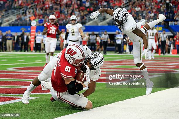 Troy Fumagalli of the Wisconsin Badgers scores a touchdown against Caleb Bailey and Darius Phillips of the Western Michigan Broncos in the fourth...