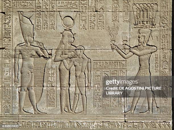 The Roman emperor Trajan depicted as pharaoh offers flowers, a symbol of beauty, and a sistrum, a symbol of music, to the goddess Hathor...