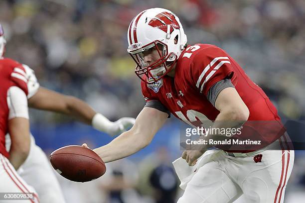 Bart Houston of the Wisconsin Badgers hands the ball off in the fourth quarter during the 81st Goodyear Cotton Bowl Classic between Western Michigan...