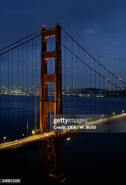 View of the Golden Gate Bridge, 1933-1937, architect Joseph Baermann Strauss, with the bay and the city of San Francisco in the background, at night,...