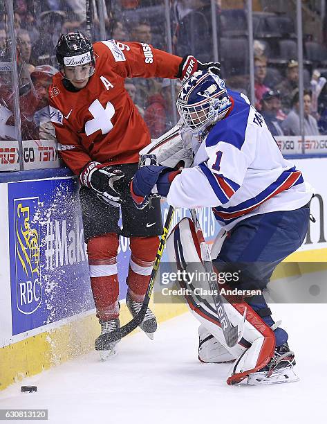 Tyler Parsons of Team USA bumps into Damien Riat of Team Switzerland during a QuarterFinal game at the 2017 IIHF World Junior Hockey Championships at...