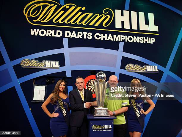 Simon Kew, Head of trading for William Hill Online and Michael van Gerwen with the Sid Waddell trophy during day fifteen of the William Hill World...