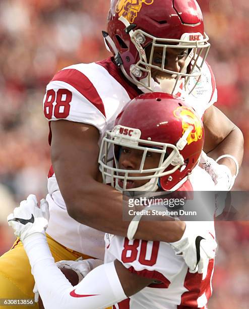 Wide receiver Deontay Burnett of the USC Trojans celebrates with tight end Daniel Imatorbhebhe after catching a 26-yard touchdown in the first...