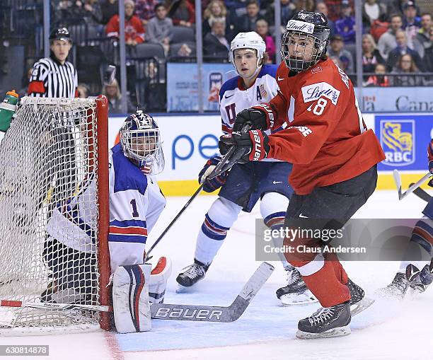 Tyler Parsons of Team USA guards the corner against Nico Hischiser of Team Switzerland during a QuarterFinal game at the 2017 IIHF World Junior...