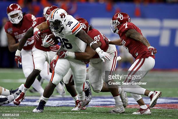 Kamryn Pettway of the Auburn Tigers is tackled by Nick Basquine of the Oklahoma Sooners during the Allstate Sugar Bowl at the Mercedes-Benz Superdome...