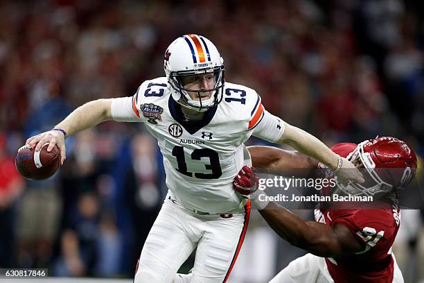 Sean White of the Auburn Tigers avoids a tackle by Derek Cole of the Oklahoma Sooners during the Allstate Sugar Bowl at the Mercedes-Benz Superdome...