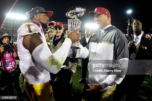 Wide receiver Darreus Rogers of the USC Trojans and head coach Clay Helton celebrate with the 2017 Rose Bowl trophy after defeating the Penn State...