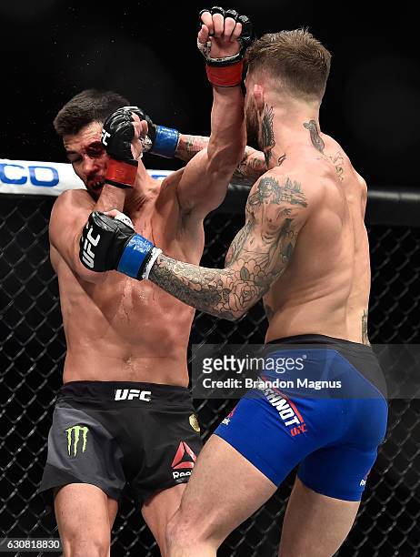 Cody Garbrandt punches Dominick Cruz in their UFC bantamweight championship bout during the UFC 207 event at T-Mobile Arena on December 30, 2016 in...