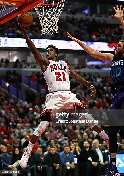 Jimmy Butler of the Chicago Bulls puts up a shot past Spencer Hawes of the Charlotte Hornets on his way to a game-high 52 points at the United Center...