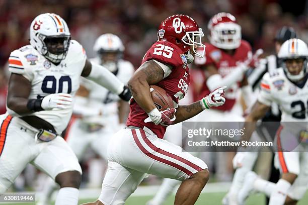 Joe Mixon of the Oklahoma Sooners runs with the ball against the Auburn Tigers during the Allstate Sugar Bowl at the Mercedes-Benz Superdome on...