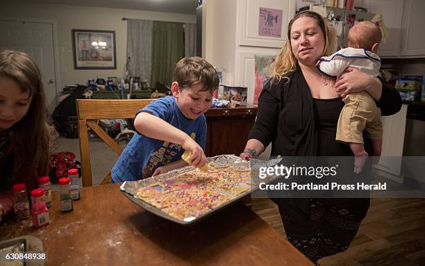 From left, Roxy Rovin Everett Rovin and their Mom, Amy Starr, bake and decorate Hanukkah cookies at their home in Gorham. The family is also helping...