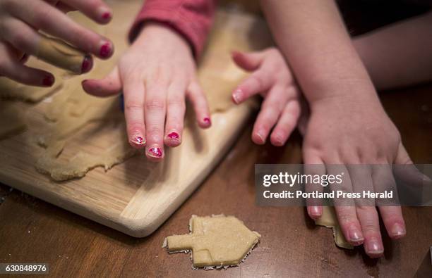 From left, Roxy Rovin Everett Rovin and their Mom, Amy Starr, bake and decorate Hanukkah cookies at their home in Gorham. The family is helping...