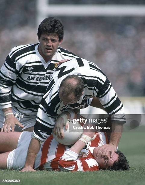 Mike Ford of Wigan is held down by Steve Norton of Hull, as John Muggleton looks on, during the Silk Cut Rugby League Challenge Cup final against...