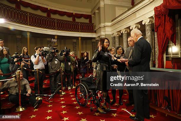 Sen. Tammy Duckworth participates in a reenacted swearing-in with U.S. Vice President Joe Biden in the Old Senate Chamber at the U.S. Capitol January...