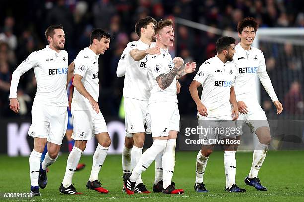 Alfie Mawson of Swansea City celebrates scoring the opening goal with his team mates during the Premier League match between Crystal Palace and...