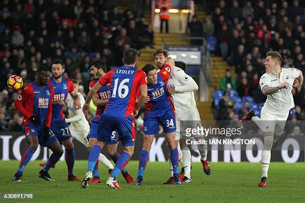 Swansea City's English defender Alfie Mawson heads the opening goal of the English Premier League football match between Crystal Palace and Swansea...
