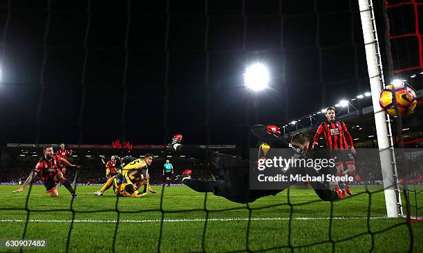 Artur Boruc of AFC Bournemouth dives in vain as Olivier Giroud of Arsenal scores his team's third goal during the Premier League match between AFC...
