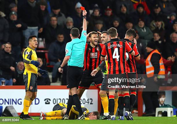 Simon Francis of AFC Bournemouth reacts after receiving a red card by referee Michael Oliver after tackling on Aaron Ramsey of Arsenal during the...