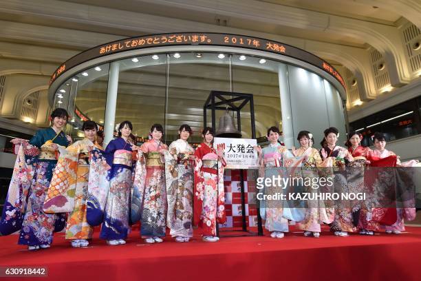 Women wearing traditional kimono outfits pose after the opening of the stock market for the year at the Tokyo Stock Exchange in Tokyo on January 4,...