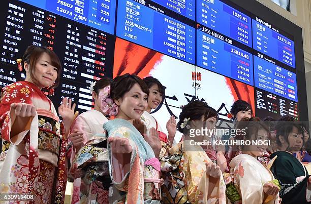 Women wearing traditional kimono outfits pose after the opening of the stock market for the year at the Tokyo Stock Exchange in Tokyo on January 4,...
