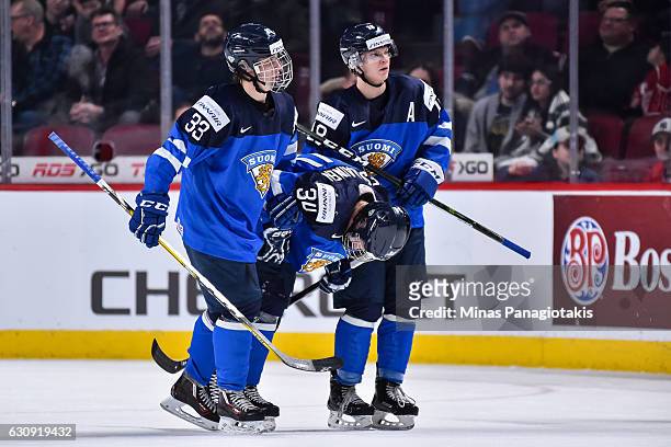 Eeli Tolvanen and Vili Saarijarvi of Team Finland carry out teammate Kristian Vesalainen during the 2017 IIHF World Junior Championship relegation...